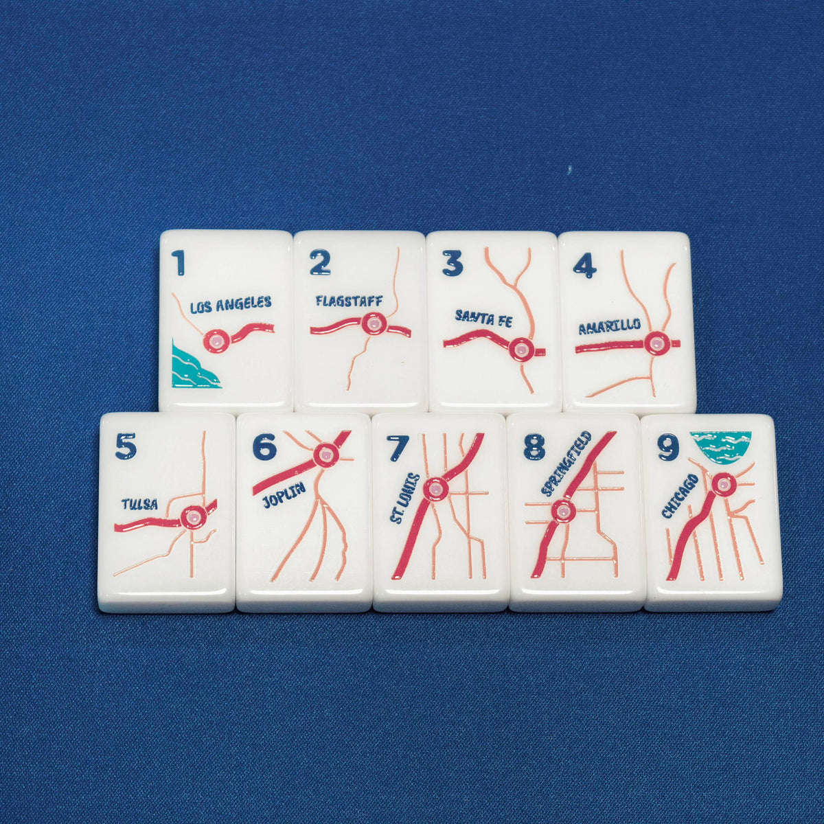 Flat lay of 1-9 bamboo suit mahjong tiles, US highway route map graphics marking Los Angeles, Santa Fe, Chicago and other American cities