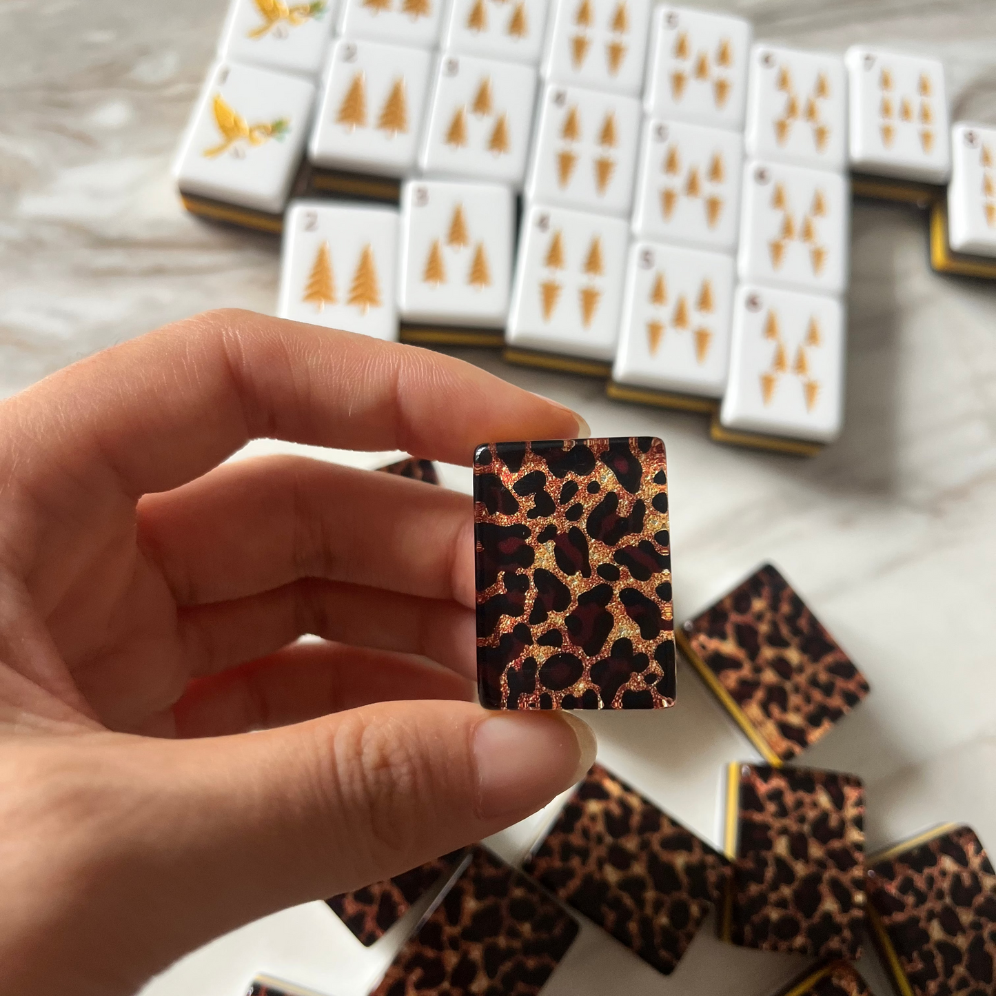 Close-up of leopard joker mahjong tile, roaring leopard illustration on white tile face, gold glitter leopard printed tile reverse