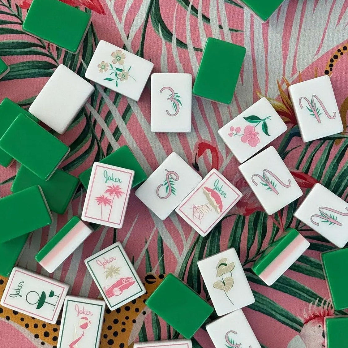 This fun retro‑vacation style mahjong set features stunning three‑layer tile backs in green‑pink‑white gradient, paired with hand‑drawn tropical artwork across tile faces. Enjoy playful joker tiles featuring flamingos, palm trees, retro cars, poolside cocktails, pineapples and swim‑suit motifs. Suits include shell‑styled dots, banana‑leaf bamboo, tropical floral character tiles, decorative tropical‑theme wind tiles and vivid bird accents. Complete 166‑tile set fully compliant with official American mahjong 