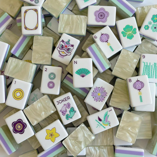 Piled Bloom lavender mint American mahjong tiles, layered mint green and lavender purple backs, white faces with lion dance, koi joker, fan winds, lantern and floral artwork