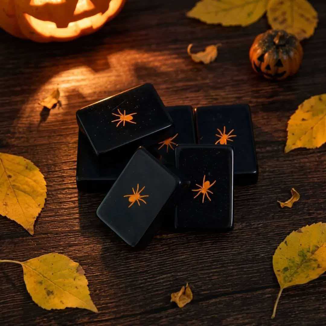 Spooky Hallow mahjong scattered tiles close‑up, glossy black backs with orange spider print, pumpkin and autumn leaves background, Halloween themed American mahjong tiles