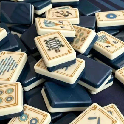Imperial Navy mahjong tiles close‑up, gold‑bordered cream tiles with turtle joker, coin dot, Chinese character wan, fan wind and crane artwork, glossy deep navy‑blue tile backs, 160‑tile American mahjong set