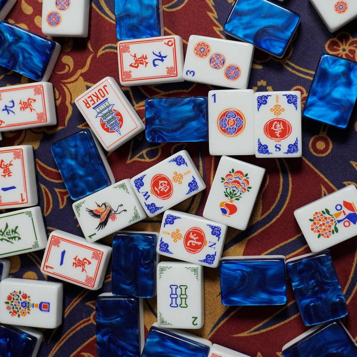 A masterpiece of craftsmanship and color. The Pagoda Sapphire features stunning marbled sapphire-blue acrylic backs paired with bright white tile faces and intricate traditional engravings including our signature red pagoda Joker. Tournament-grade NMJL compliance meets heirloom-level beauty.