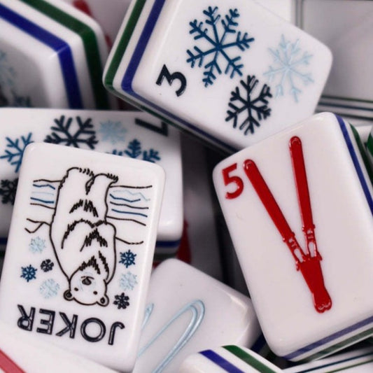 Frosty Peak mahjong close‑up shot, polar bear joker tile, red ski tile, blue snowflake suit tiles, multi‑color layered stripe backs, winter‑sports custom American mahjong pieces