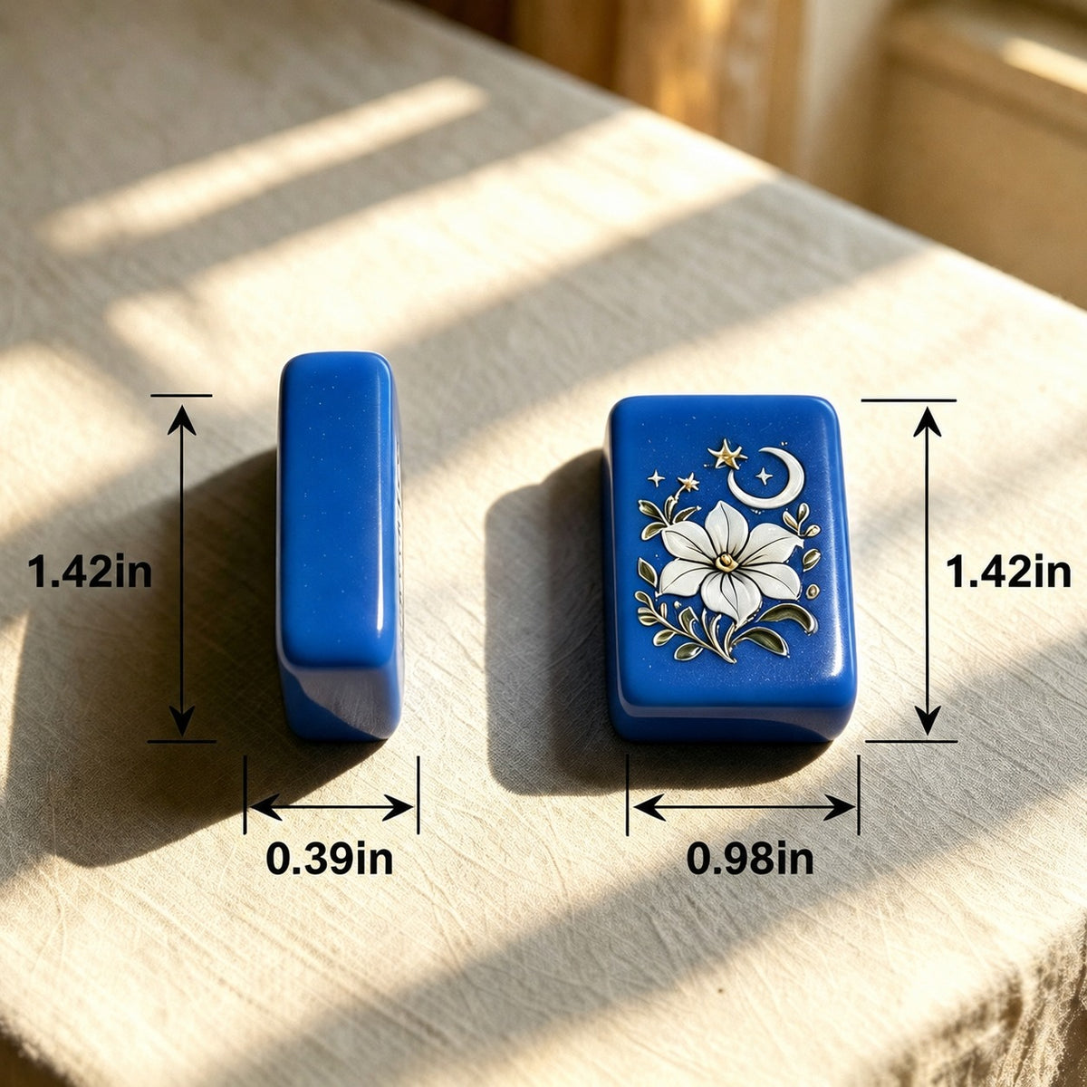 Side profile shot of Blue Chinoiserie mahjong tiles lined on dark wooden rack, glossy cobalt tiles displaying garden joker scenes, pink and white swan dragon tiles and floral SOAP tile