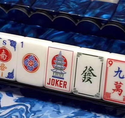 A masterpiece of craftsmanship and color. The Pagoda Sapphire features stunning marbled sapphire-blue acrylic backs paired with bright white tile faces and intricate traditional engravings including our signature red pagoda Joker. Tournament-grade NMJL compliance meets heirloom-level beauty.
