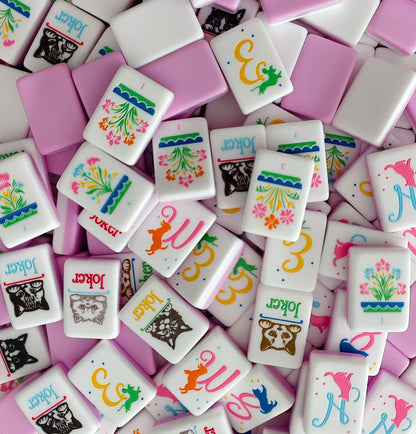 Flat lay of dog breed mahjong tiles, featuring poodle, labrador, french bulldog illustrations printed on white mahjong tiles