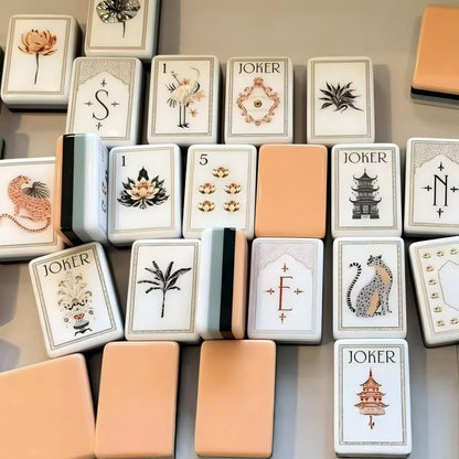 This elegant oriental‑botanical mahjong set features eye‑catching multi‑layer stacked tile backs: soft peach‑coral top layer, deep forest‑green, mint‑blue and white layered core. Tile fronts are creamy off‑white with fine vintage border details, adorned with hand‑drawn oriental artwork: lotus‑flower dot tiles, natural bamboo‑stalk bamboos, ornate pagoda‑lantern character tiles, tropical botanical flower tiles, arch‑frame wind tiles, and whimsical exotic‑creature &amp; architecture‑themed jokers. Fully compl