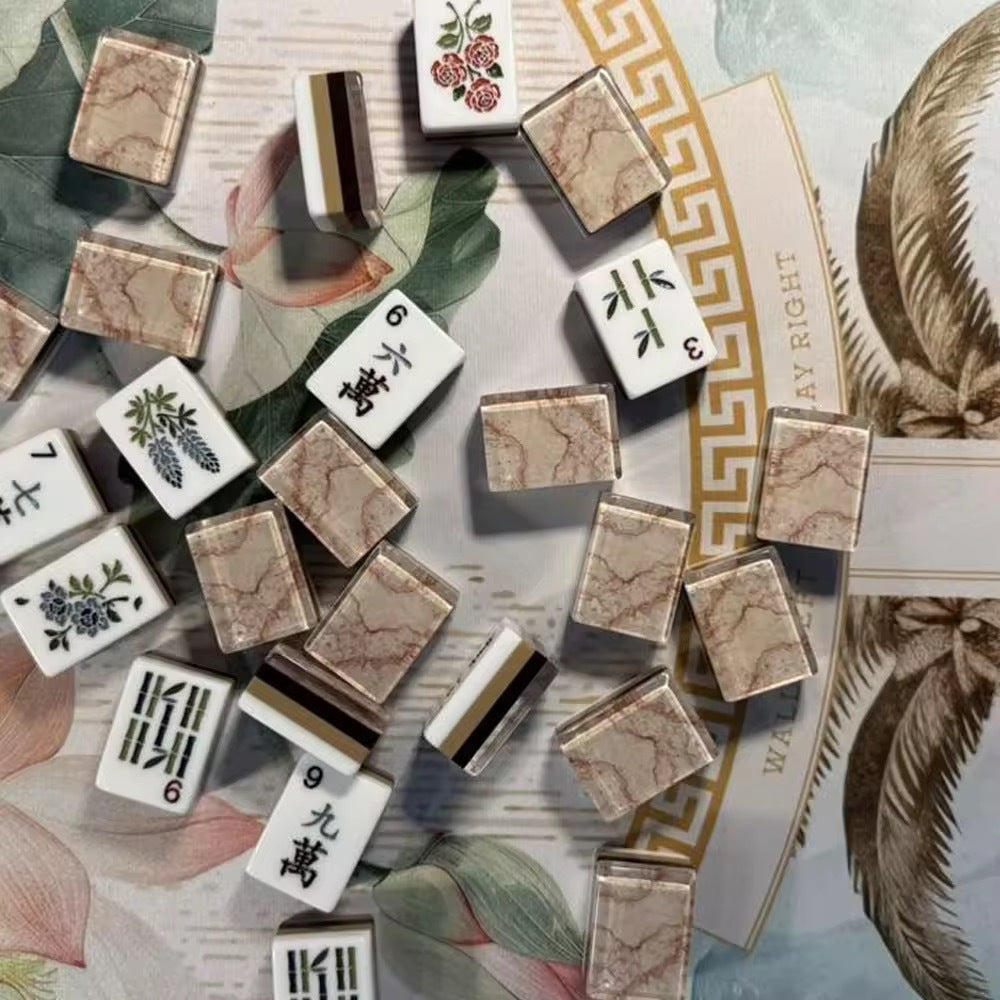 Flat lay of Pink Marble Floral American mahjong tiles arranged neatly on clean white background, white tile fronts with green floral dot patterns, classic bamboo, red dragons, multi-color flower tiles and crown jokers