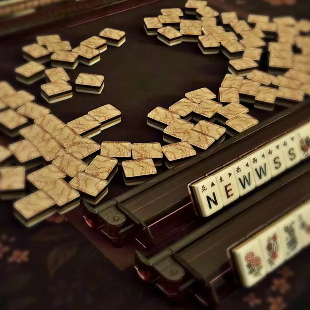 Flat lay of Pink Marble Floral American mahjong tiles arranged neatly on clean white background, white tile fronts with green floral dot patterns, classic bamboo, red dragons, multi-color flower tiles and crown jokers