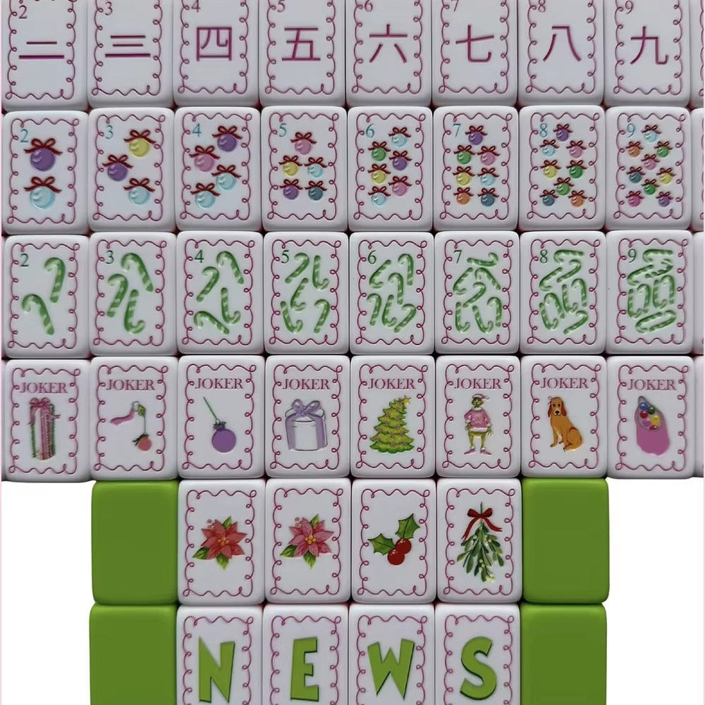 Flat lay display of full Christmas Grinch mahjong set, showing complete suit tiles, wind tiles and holiday joker tiles with pink scalloped borders
