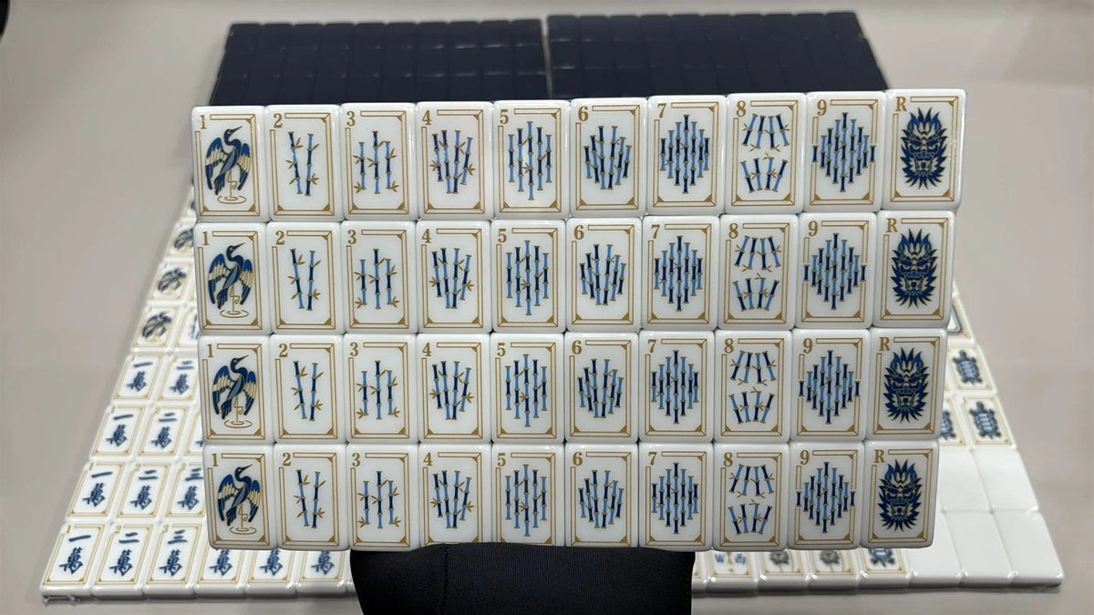 Evoking timeless oriental elegance, this Imperial Navy American mahjong set features luxe gold‑bordered cream tile faces decorated with classic East‑Asian wildlife and botanical art. Graceful cranes, symbolic turtle jokers, fierce dragon motifs, lush lotus florals, coin‑styled dot tiles and ornate fan‑shaped wind tiles elevate every suit. Rich deep navy‑blue high‑gloss tile backs deliver a premium, sophisticated finished look.