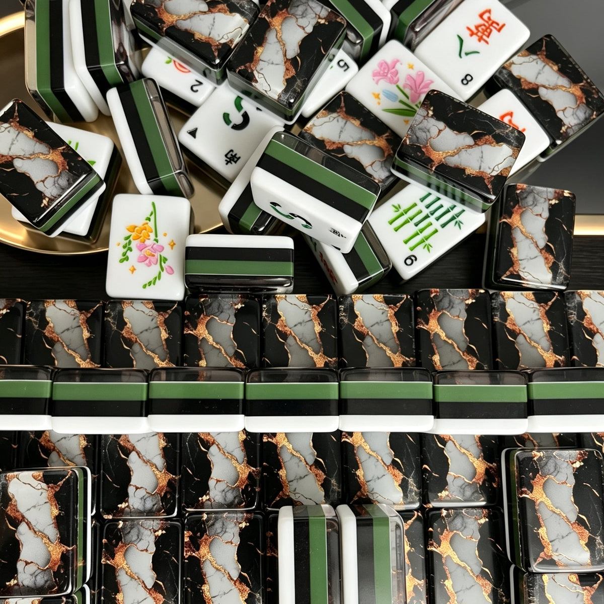 Pile of black gold marble American mahjong tiles on golden tray, gold cracked marble tile backs, green-black-white side stripes, custom peacock and floral tile art