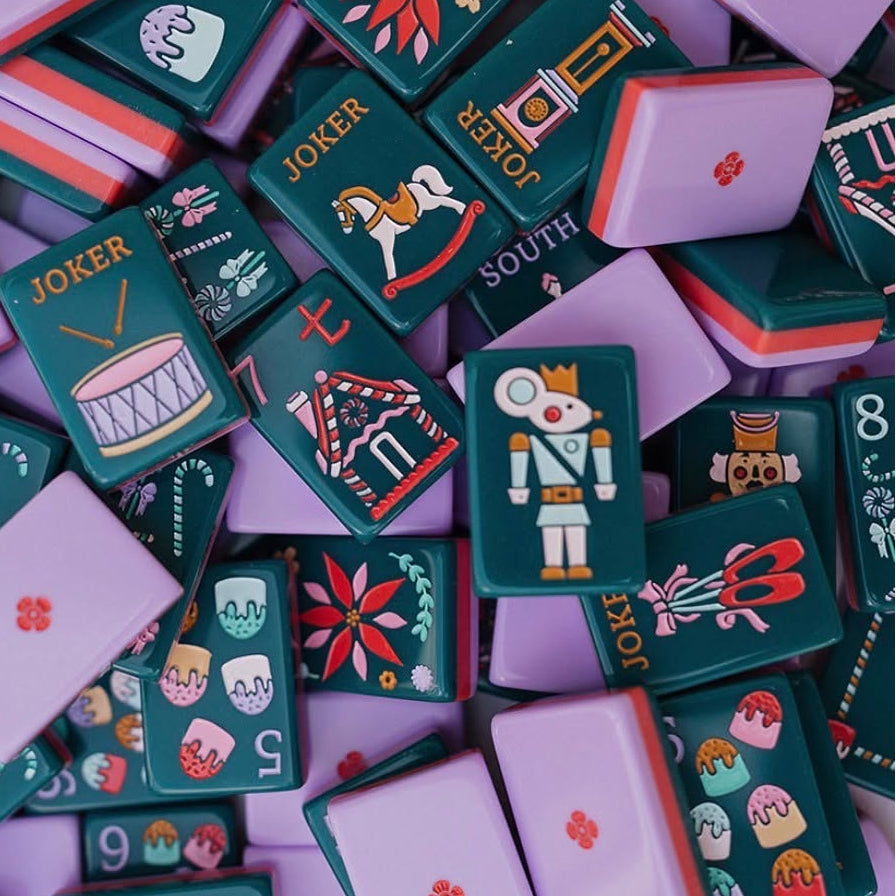 The most magical mahjong set of the season.The Holiday Nutcracker is a limited-edition collector's piece featuring rich evergreen melamine tiles adorned with hand-illustrated Christmas art from the iconic nutcracker soldier Jokers and pink ballet slipper Jokers to gingerbread house Craks, frosted cake Dots, ballerina winds (NEWS), poinsettia flowers, Christmas trees, and grandfather clocks. The ultimate holiday gift for the American Mahjong lover in your life.
