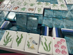Coastal Mahjong Tiles Close-up - Seagull Sailboat Sea Turtle Seahorse and Tropical Wind Tiles on Sandy Background