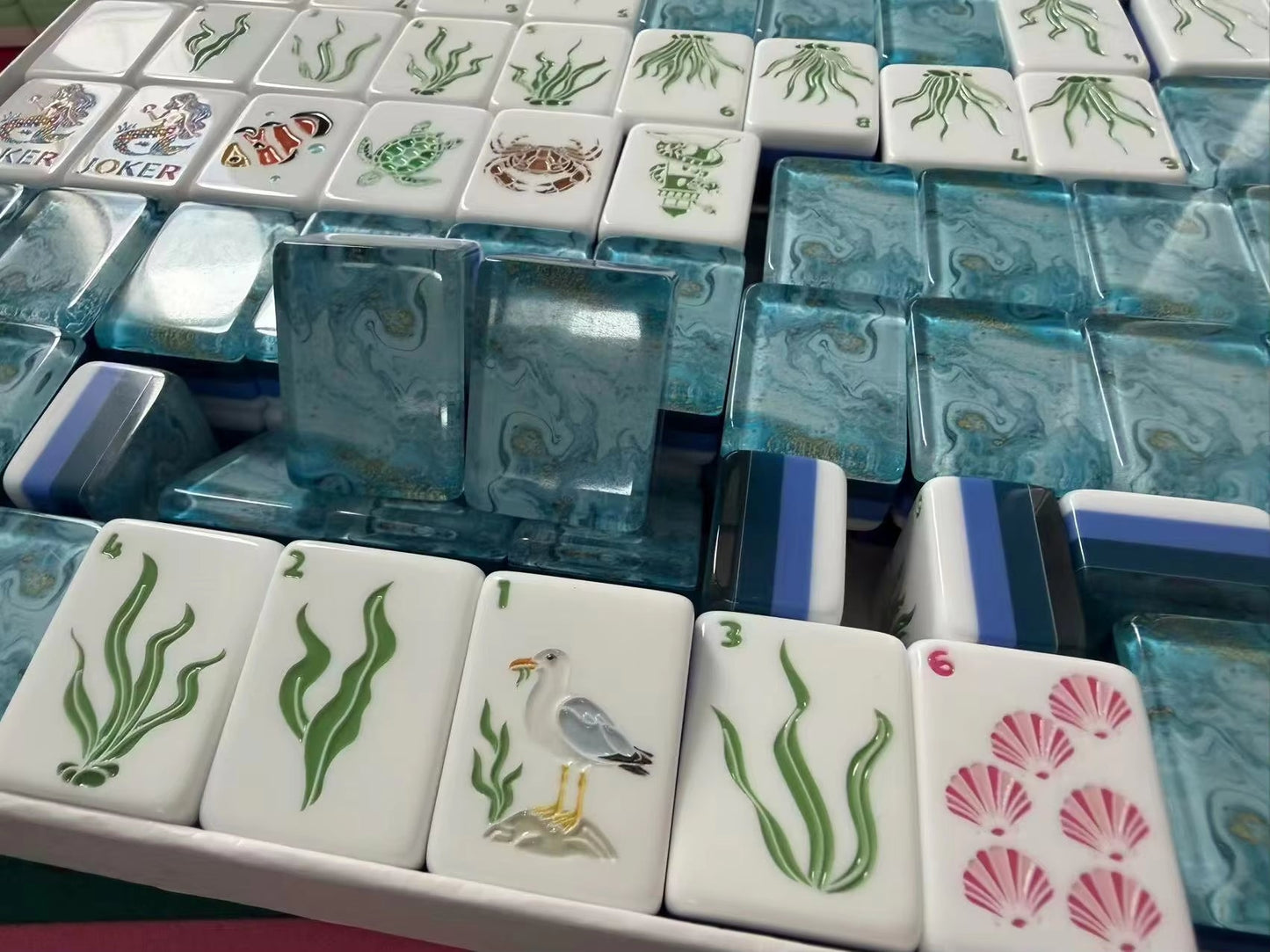 Coastal Mahjong Tiles Close-up - Seagull Sailboat Sea Turtle Seahorse and Tropical Wind Tiles on Sandy Background