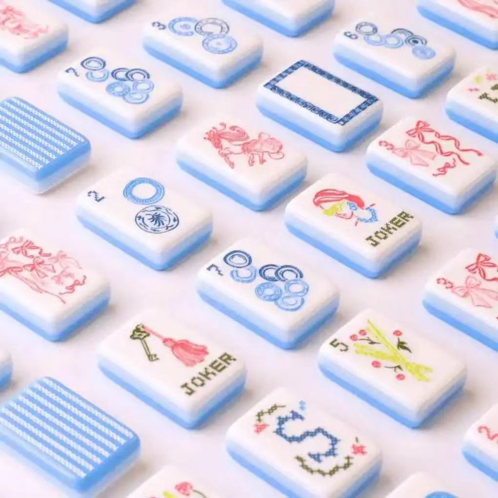 Detailed view of USA Mahjong Co. Sky Linen American Mahjong Set with blue and white striped acrylic tiles and gold inlays.