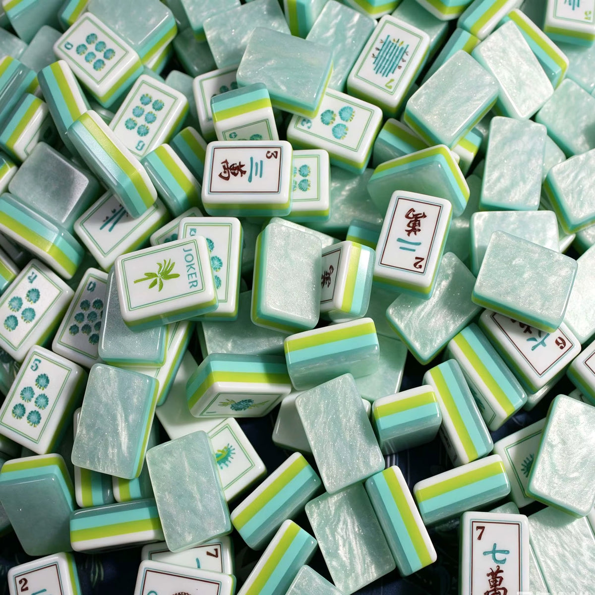 A breath of fresh sea air for your mahjong table. The Coastal Mist features soft mint-marbled acrylic backs with signature multi-layer side stripes in turquoise, lime, and white paired with crisp white faces and exclusive ocean-themed Joker and Flower illustrations. It's coastal elegance meets full NMJL tournament functionality.