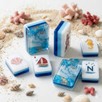 Coastal Mahjong Tiles Close-up - Seagull Sailboat Sea Turtle Seahorse and Tropical Wind Tiles on Sandy Background