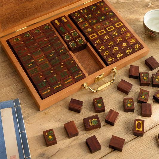Solid red wood American mahjong set laid out for gameplay, wooden mahjong tiles with dragon embroidered coasters on light wood surface
