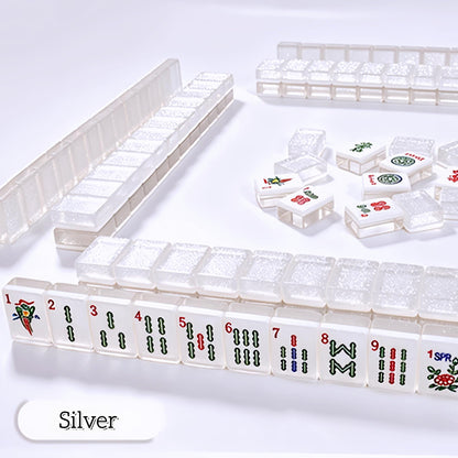 Crystal Shimmer Silver clear translucent mahjong tiles scattered on white surface, clear glitter backs, white faces with dots, bamboo, character and joker tiles, transparent acrylic American mahjong