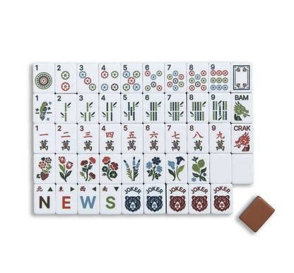 Wildwood Bear mahjong overhead scattered shot, mixed character, dot and bamboo tiles, mocha‑brown layered backs, rustic botanical bear‑joker American mahjong set