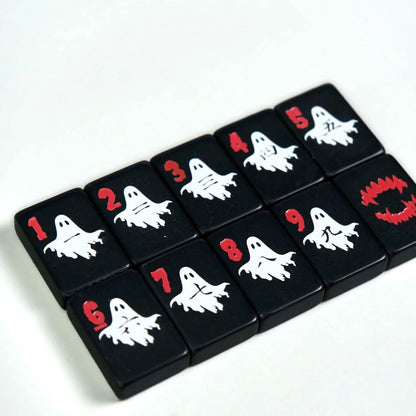 Spooky Hallow mahjong overhead flat‑lay on white background, full Halloween themed tile assortment, ghost, pumpkin, skull and spooky joker tiles, black base American mahjong pieces