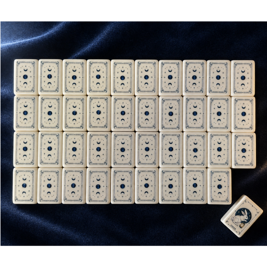 Full flat lay layout of Moon Rabbit Tarot American mahjong tiles on dark background, cream tiles featuring moon star dots, flower bamboo suits, zodiac animal wind tiles, floral season tiles and moon rabbit joker